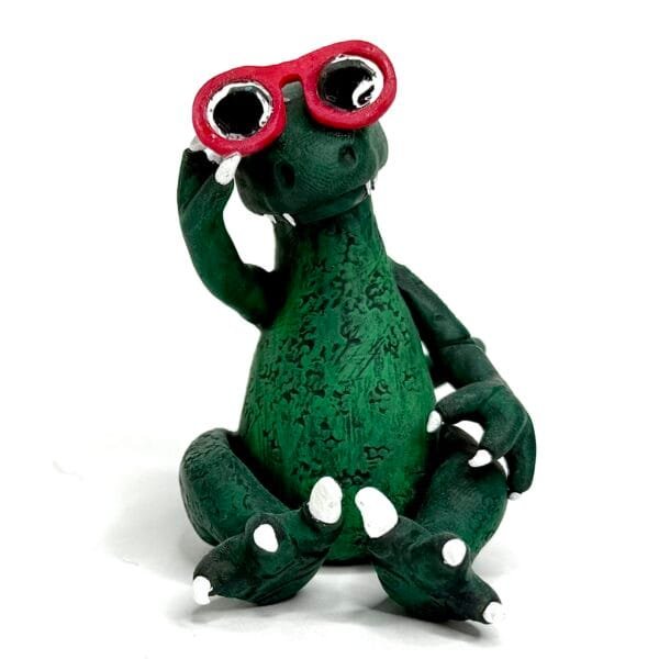 Handmade Jurassic Zubaloo velociraptor in green polymer clay with leaves